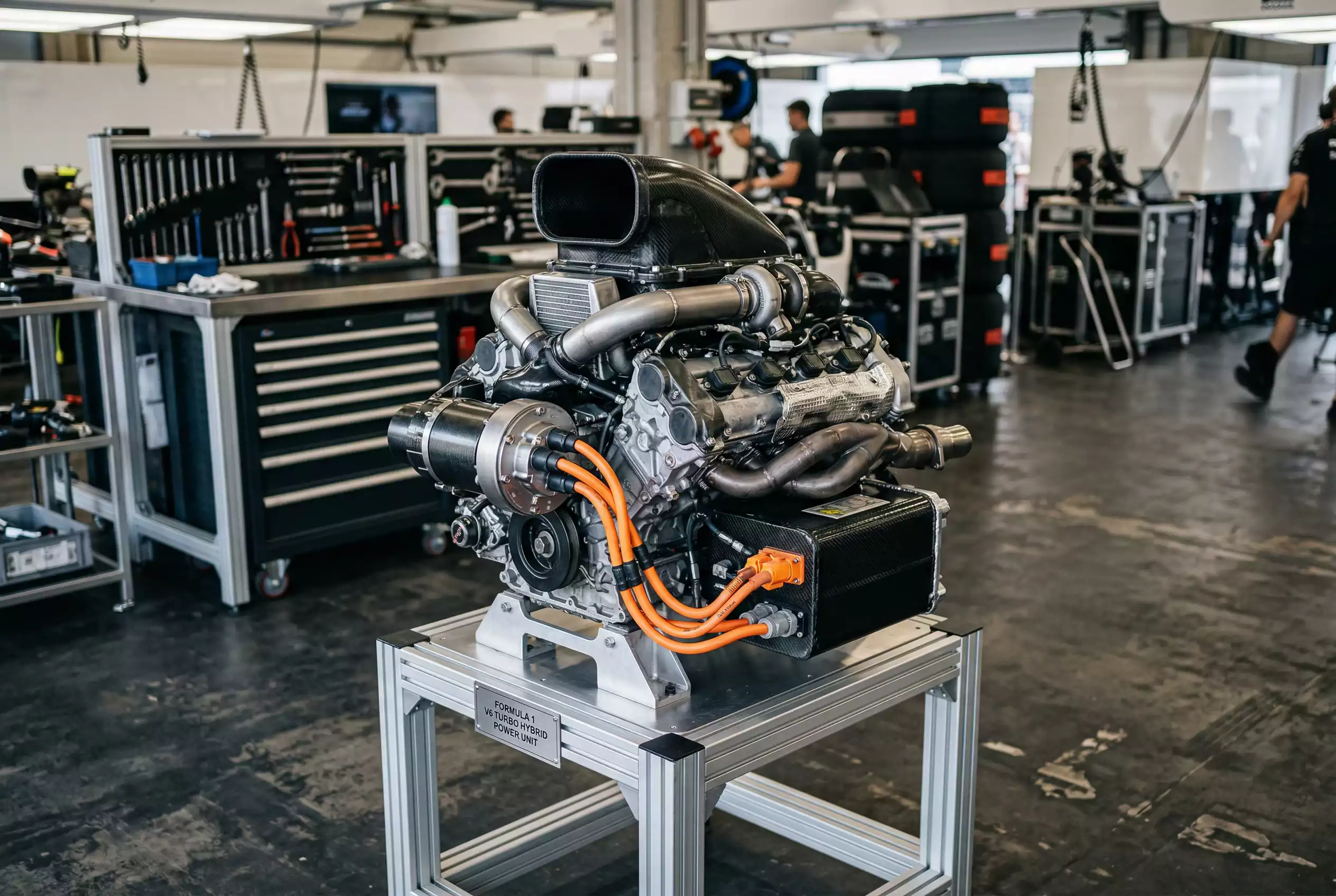 Offene Formel-1-Power-Unit mit sichtbarem Elektromotor und Batterieeinheit in einer Teamgarage